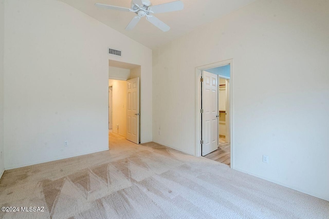 unfurnished bedroom with ceiling fan, light colored carpet, and vaulted ceiling