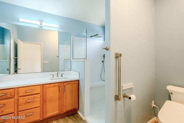 bathroom with wood-type flooring, vanity, toilet, and walk in shower