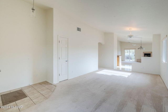 unfurnished living room featuring ceiling fan and light carpet