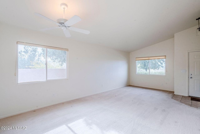 carpeted spare room with ceiling fan and vaulted ceiling