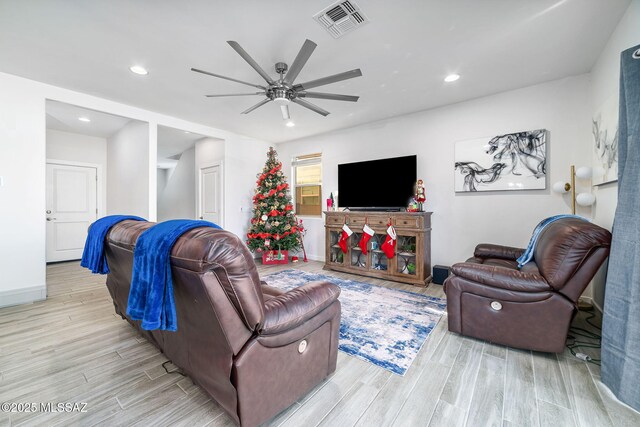 living room featuring ceiling fan and light hardwood / wood-style flooring