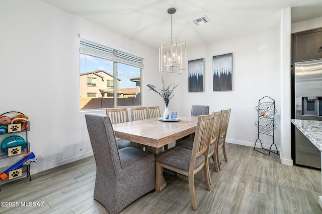 dining space with an inviting chandelier and light wood-type flooring