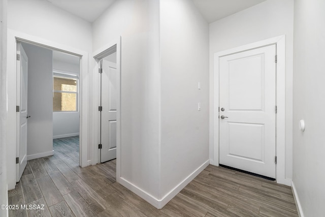 corridor with hardwood / wood-style flooring