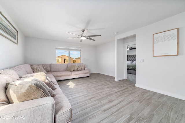 living room with ceiling fan and light wood-type flooring