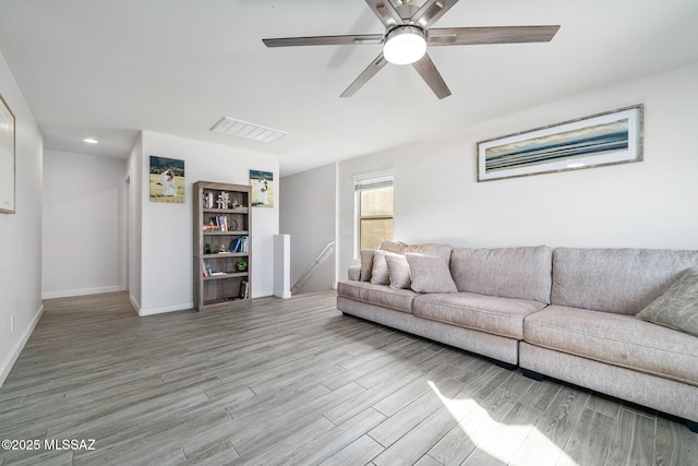 living room with ceiling fan and light hardwood / wood-style flooring