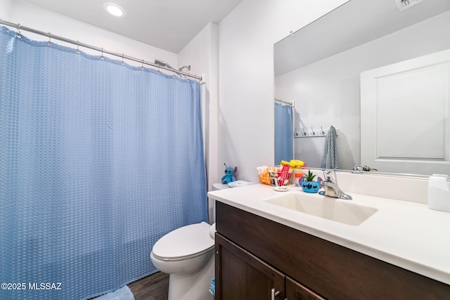 bathroom featuring hardwood / wood-style flooring, vanity, a shower with curtain, and toilet