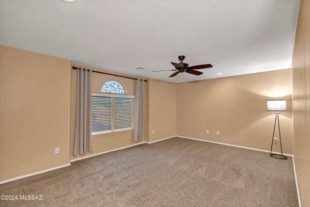 unfurnished room with carpet and ceiling fan