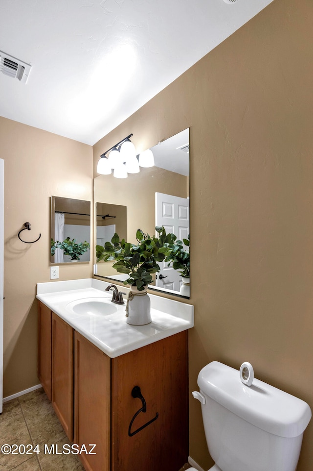 bathroom featuring tile patterned flooring, vanity, and toilet