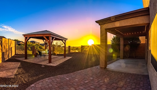 patio terrace at dusk featuring a gazebo