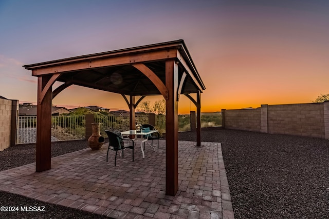 patio terrace at dusk featuring a gazebo