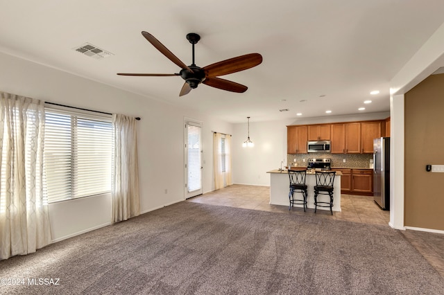 tiled living room featuring ceiling fan with notable chandelier