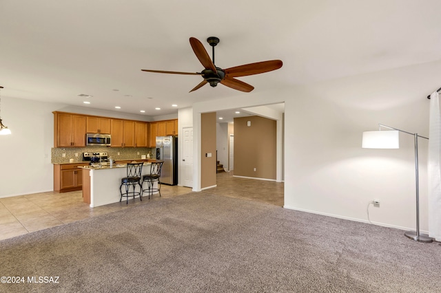 unfurnished living room with ceiling fan and light carpet