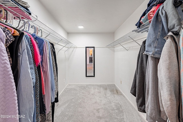 walk in closet featuring light carpet