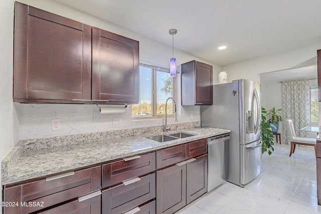 kitchen featuring light stone counters, dark brown cabinetry, sink, decorative light fixtures, and dishwasher