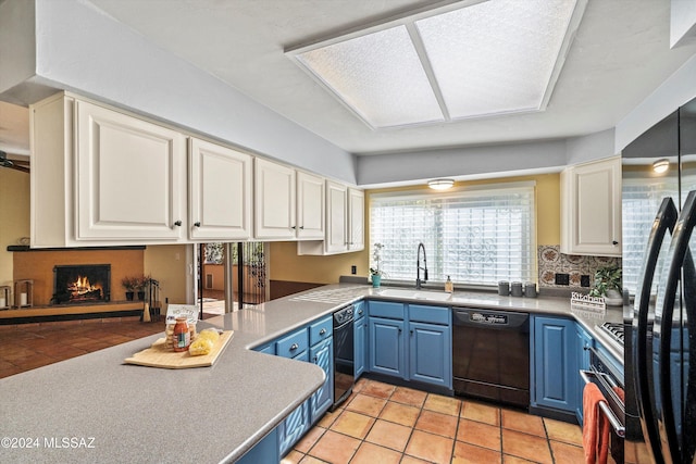 kitchen with blue cabinetry, sink, black dishwasher, and fridge