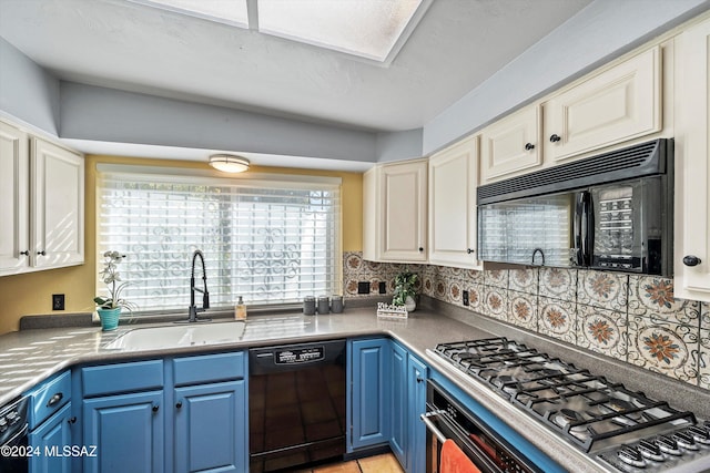 kitchen with black appliances, sink, blue cabinetry, and backsplash