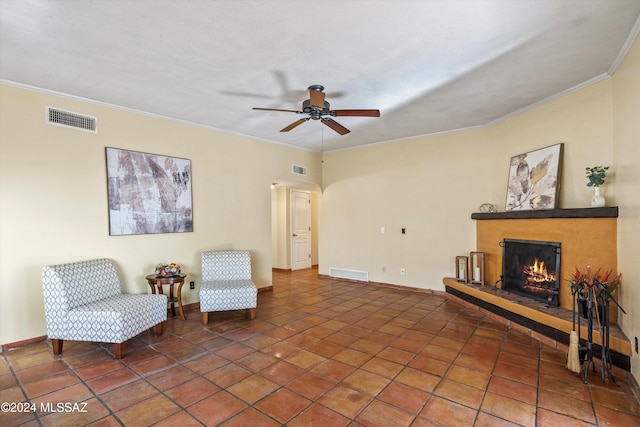 living area featuring crown molding, dark tile patterned floors, and ceiling fan