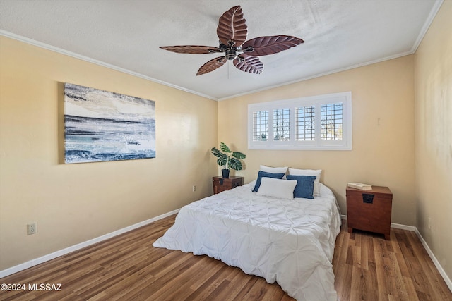 bedroom with ceiling fan, hardwood / wood-style floors, a textured ceiling, and ornamental molding