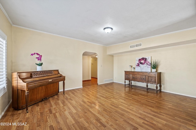 miscellaneous room with wood-type flooring and ornamental molding