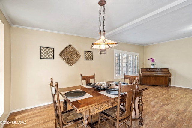 dining space featuring crown molding and light wood-type flooring