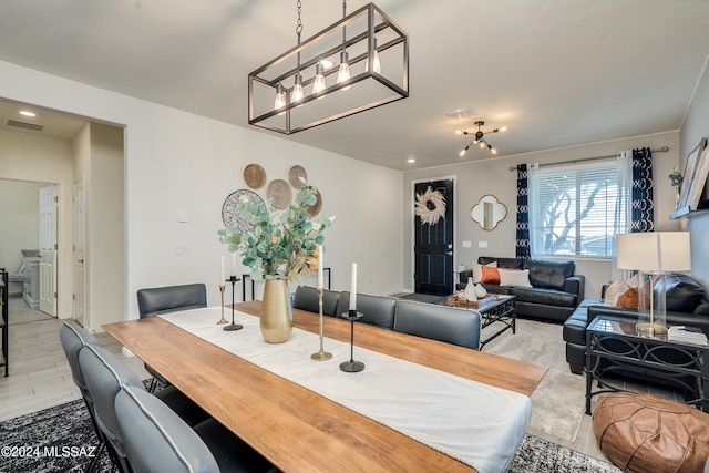 dining space with a chandelier and light hardwood / wood-style floors