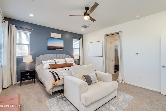 bedroom featuring multiple windows, ceiling fan, and light colored carpet