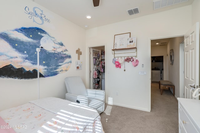 carpeted bedroom featuring a walk in closet, washer / clothes dryer, a closet, and ceiling fan