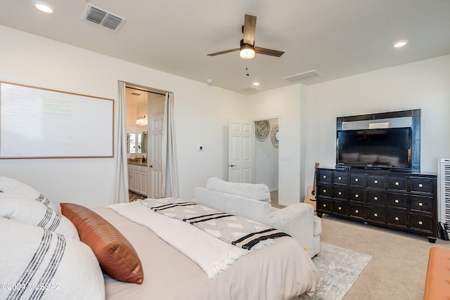 bedroom featuring ceiling fan, light carpet, and connected bathroom