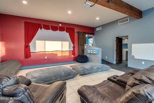 living room with beam ceiling, a barn door, and light tile patterned floors