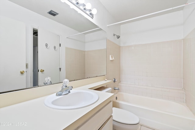 full bathroom featuring vanity, tiled shower / bath combo, and toilet