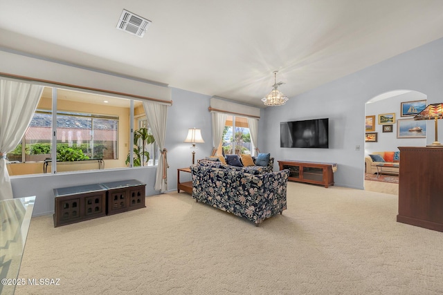 living room with vaulted ceiling, an inviting chandelier, and carpet flooring