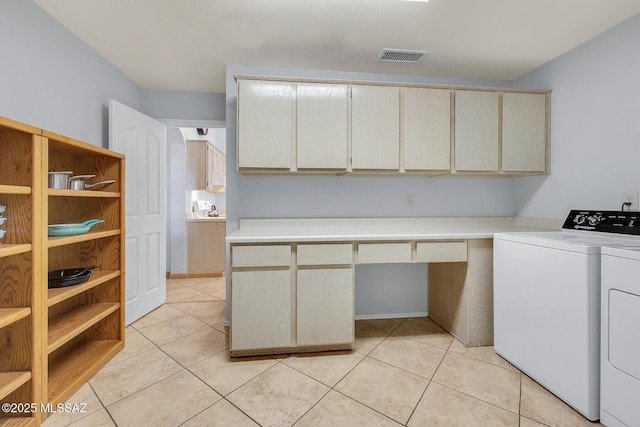 laundry room featuring cabinets, light tile patterned floors, and separate washer and dryer