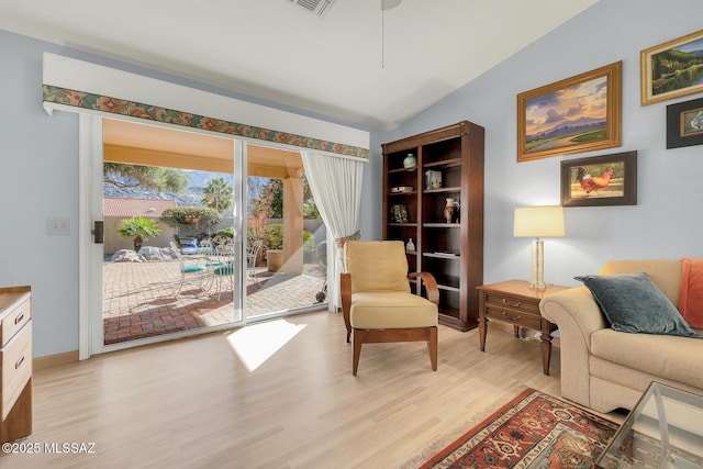 living area featuring vaulted ceiling and light wood-type flooring