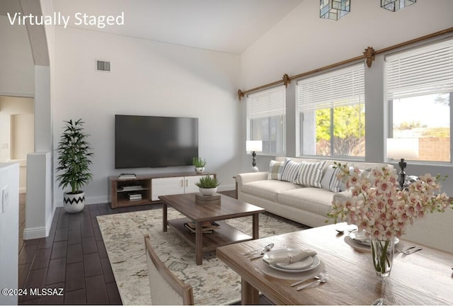 living room with dark hardwood / wood-style flooring and high vaulted ceiling