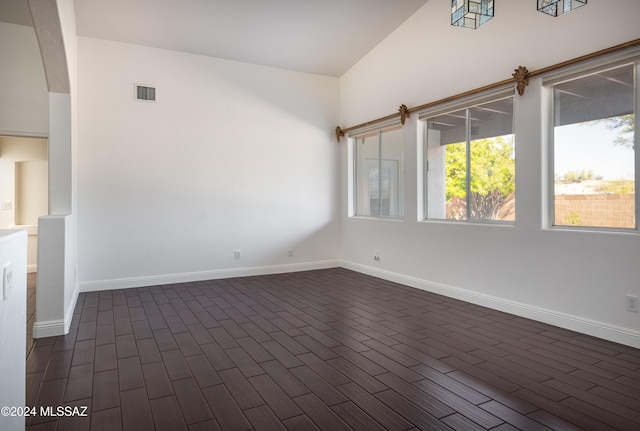 empty room featuring dark hardwood / wood-style flooring and lofted ceiling