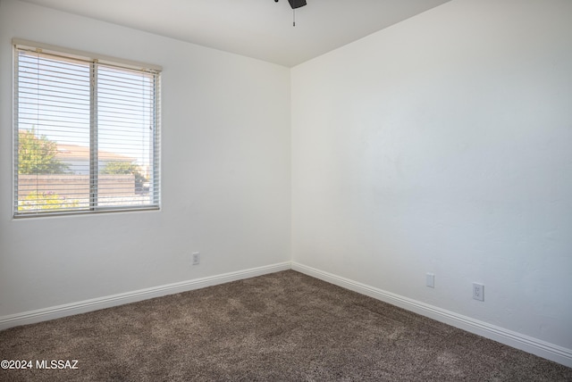 carpeted spare room featuring plenty of natural light and ceiling fan