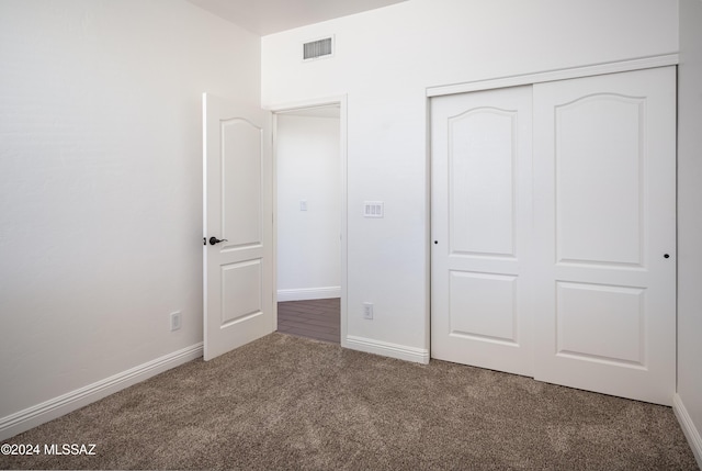 unfurnished bedroom featuring carpet flooring and a closet