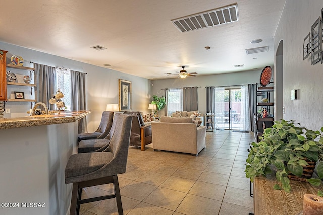 tiled living room with ceiling fan