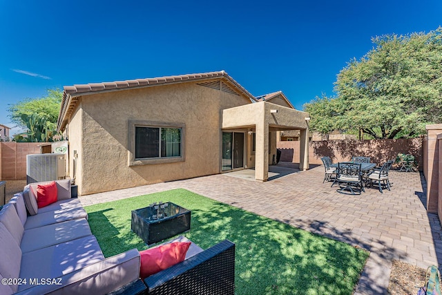 rear view of property featuring a patio area and an outdoor living space