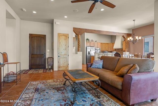 living room featuring ceiling fan with notable chandelier and tile patterned floors