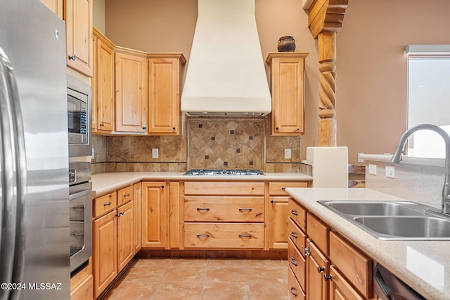 kitchen with tasteful backsplash, sink, custom range hood, and appliances with stainless steel finishes