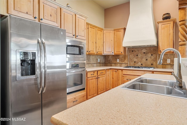 kitchen with sink, light brown cabinets, stainless steel appliances, tasteful backsplash, and premium range hood