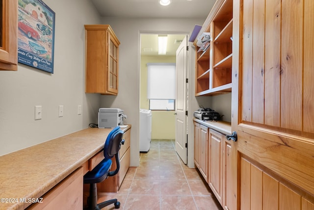 home office featuring independent washer and dryer, built in desk, and light tile patterned floors