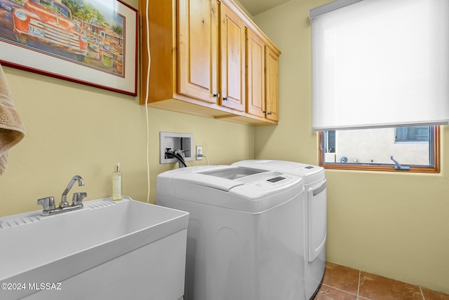 laundry room with washer and clothes dryer, sink, light tile patterned flooring, and cabinets