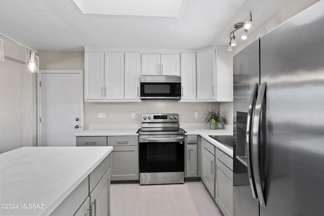 kitchen with gray cabinets, white cabinetry, hanging light fixtures, and appliances with stainless steel finishes