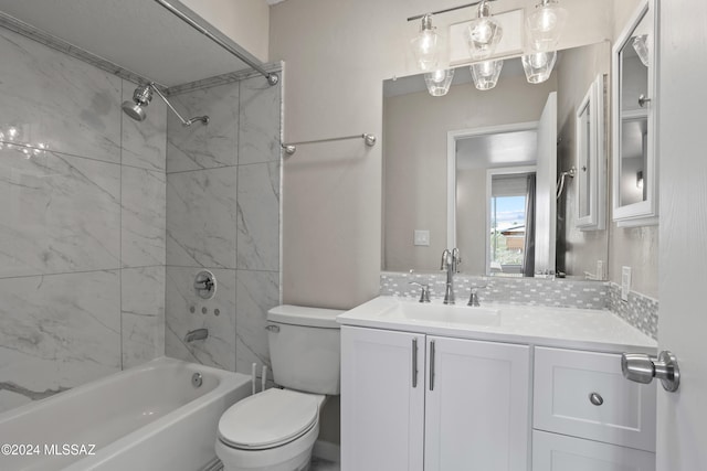 full bathroom featuring tiled shower / bath, vanity, and toilet