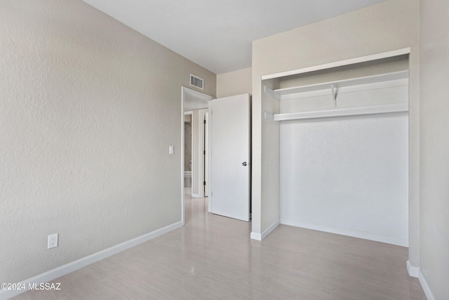 unfurnished bedroom featuring wood-type flooring and a closet