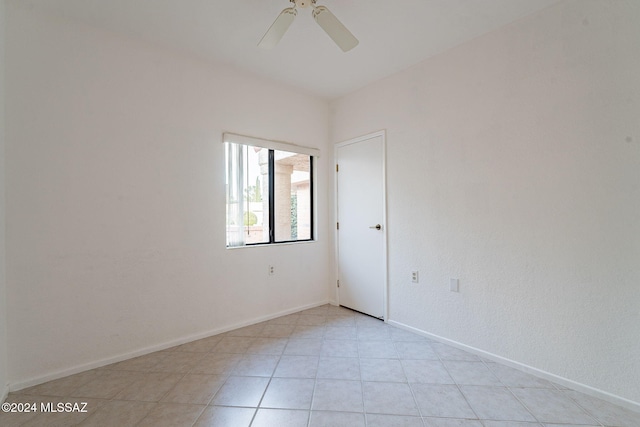 empty room featuring ceiling fan and light tile patterned floors