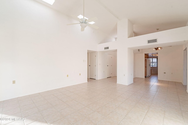 spare room featuring light tile patterned floors, high vaulted ceiling, and ceiling fan