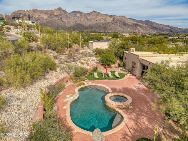 view of pool with a mountain view and an in ground hot tub